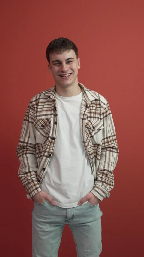 Portrait of young man stand in front red background studio shot Stock Footage 300789496
