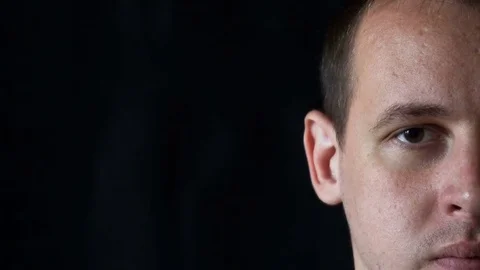 Portrait of a young man staring at camera,black background Stock Footage 76522921