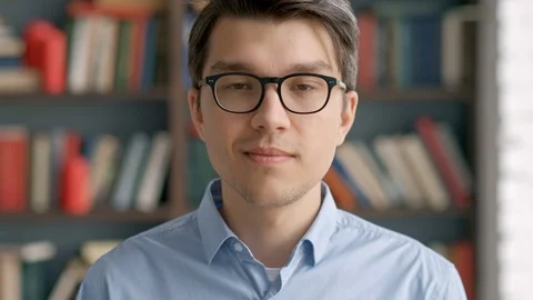 Portrait young man student smiling bookshelf library university Stock Footage 97669989