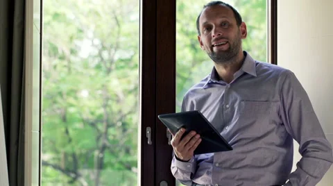 Portrait of young man with tablet standing by the window HD Stock Footage 44793940