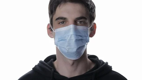Portrait of a young man taking off his medical mask and smiling on a white Stock-Footage 129832673