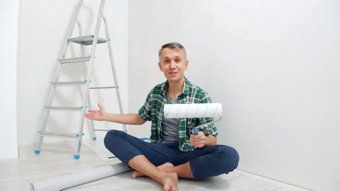 Portrait of a young man talking about paint rollers and recording a video Stock Footage 143550066