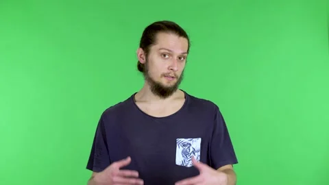 Portrait of a young man talking and pointing with his hand at something. Bearded Stock Footage 150738188