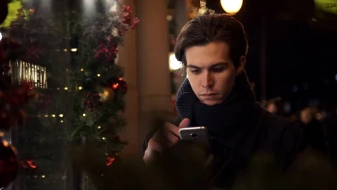 Portrait of young man using smartphone on a busy city street in evening Stock Footage 83630828