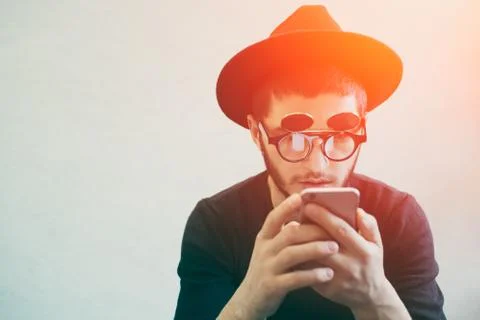 Portrait of young man using smartphone, standing over white background. Dressed Stock Photos