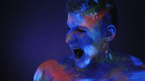 Portrait of young man in UV paint, he screams with his mouth wide open. Stock Footage 145868075
