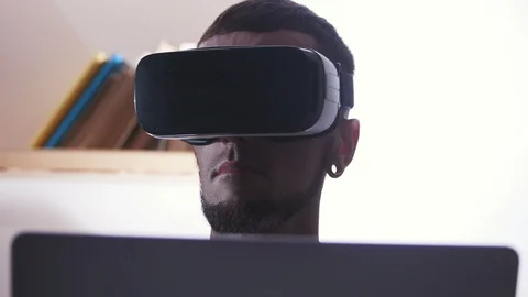 Portrait of young man in virtual reality headset looking around. Augmented Stock Footage 98181245
