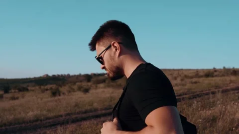 A portrait of a young man walking through the middle of a field. Active male Video stock 135445446