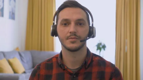 Portrait of young man with wireless headset talking with customer on video call Stock Footage 142628794