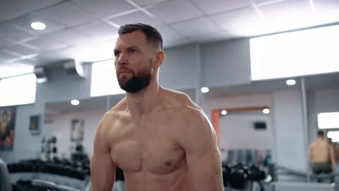 Portrait of a young man without a T-shirt who tenses his back muscles and looks Video stock 156698146
