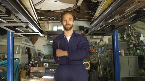 Portrait of a young mechanic working under a car Stock Footage 46308439