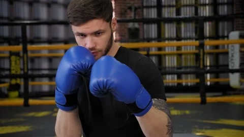 Portrait of a young muscular guy in blue boxing gloves in the gym. Stock Footage 150356629
