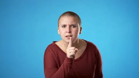 Portrait of young non binary gender fluid woman 20s looks around put finger to Stock Footage 223261840