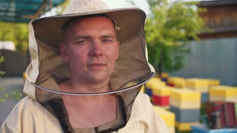 Portrait of a young owner of an apiary on which he breeds bees and extracts Stock Footage 156844516
