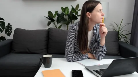 Portrait of young pensive female using laptop staying online indoors artisan Stock Footage 213859046