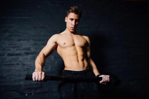 Portrait of a young physically fit man workout at gym with hammer. muscular Stock Photos