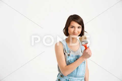 Portrait of young playful beautiful girl, holding painting bru Stock Photos