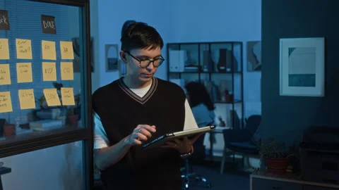 Portrait of Young Product Manager Using Digital Tablet in Dark IT Office Stock Footage 329613639