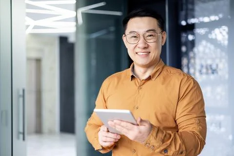 Portrait of young programmer with tablet computer inside office,asian man Foto stock