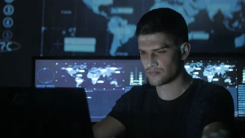 Portrait of a young programmer working at a computer in the data center filled Stock Footage 87360727