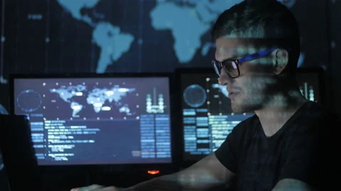 Portrait of a young programmer working at a computer in the data center filled Stock-Footage 87365846
