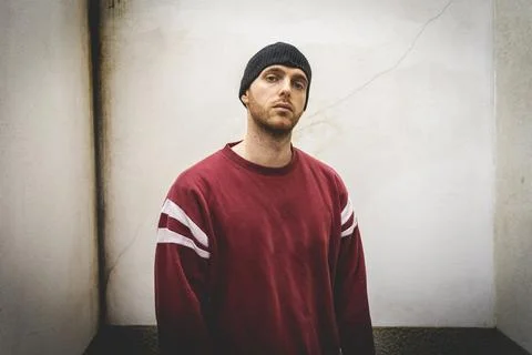 Portrait of young rapper posing in front of a white wall Stock Photos