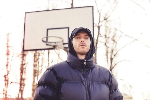 Portrait of young rapper posing in the middle of an outdoor basketball court Stock Photos