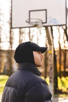 Portrait of young rapper posing in the middle of an outdoor basketball court Stock Photos