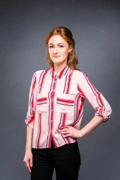Portrait of a young red-haired beautiful girl in the studio on a gray isolate Stock Photos