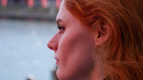 Portrait of young red haired lady looking out to sea, sadness or loneliness Video stock 78250474