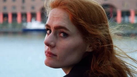 Portrait of young red haired lady looking at camera over shoulder Stock Footage 78250757