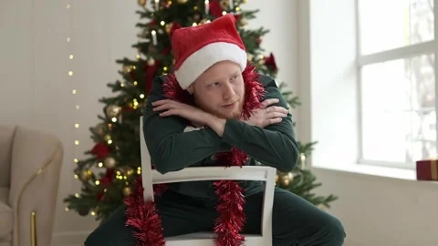 Portrait of a young red-haired man in a Santa hat. Stock Footage 294038942