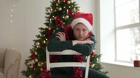 Portrait of a young red-haired man in a Santa hat. Stock Footage 294038962