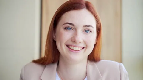 Portrait young redhead, blue eyes happy lady looking at camera indoors. Business Stock Footage 155315331