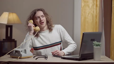 Portrait of young retro man picking up phone and talking smiling. Middle shot of Stock Footage 151358417