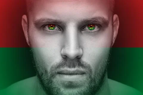 Portrait of a young serious man, in whose eyes the reflected national flag of Stock Photos