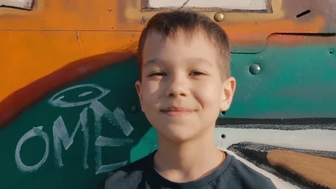 Portrait of a young smiling boy on a background of colored metal construction Stock Footage 108687394