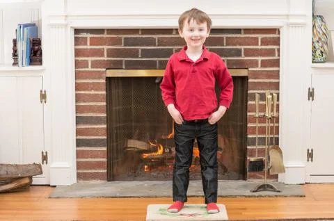 Portrait of a young smiling boy in front of a fireplace dressed for valentine's Stock Photos
