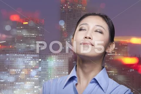 Portrait of young smiling businesswoman, cityscape of Beijing, eyes closed Stock Photos