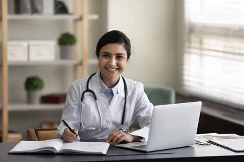 Portrait of young smiling confident indian female doctor. Stock Photos