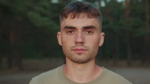 Portrait of young smiling guy who stands against the background of the forest Stock-Footage 236557467