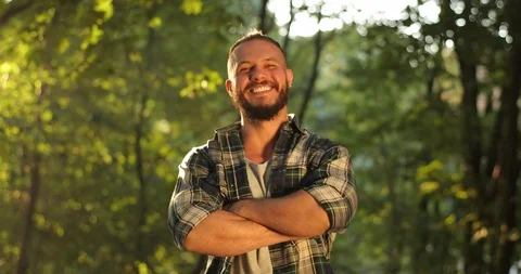Portrait of young smiling man standing in forest. People in nature. One 30s Video stock 126497175