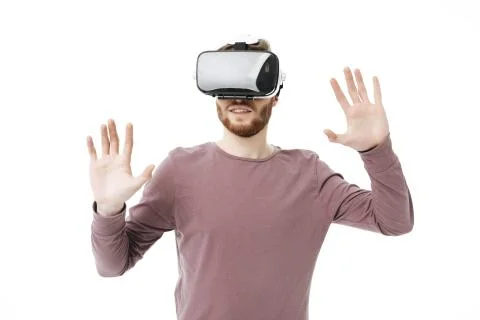 Portrait of young smiling man using virtual reality glasses on white background Stock Photos