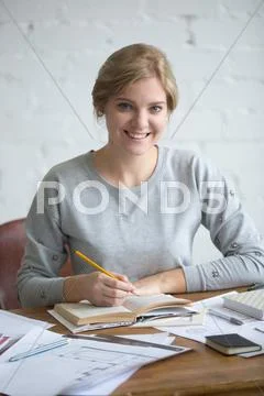 Portrait of a young smiling student at the table Stock Photos