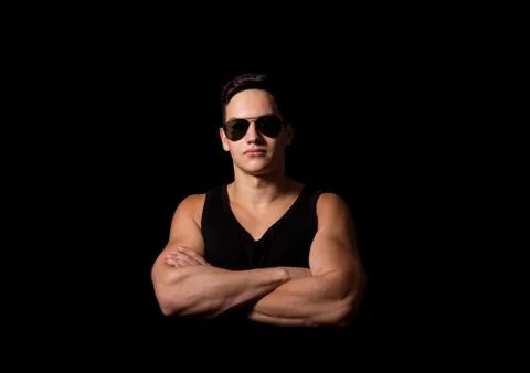 Portrait. young sporty guy in photo studio on black background. Photos