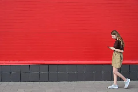 Portrait of a young student reading a message on a mobile phone, a stylish .. Stock Photos