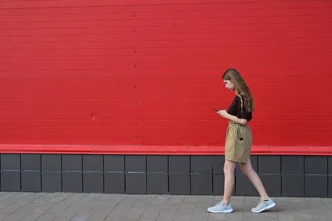 Portrait of a young student reading a message on a mobile phone, a stylish .. Stock Photos