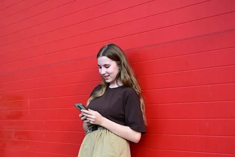 Portrait of a young student reading a message on a mobile phone, a stylish .. Stock Photos