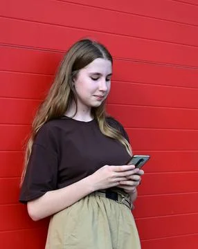 Portrait of a young student reading a message on a mobile phone, a stylish .. Stock Photos