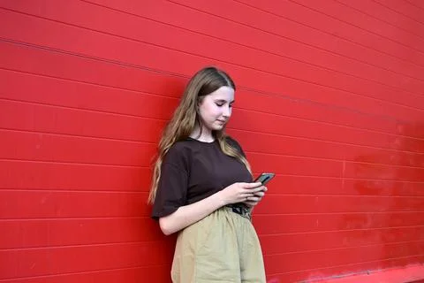 Portrait of a young student reading a message on a mobile phone, a stylish .. Stock Photos